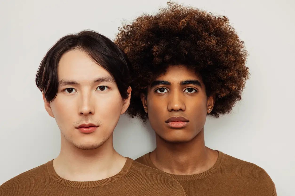 To menn, en asiatisk og en afroamerikaner, viser frem to forskjellige AI-frisyrer.