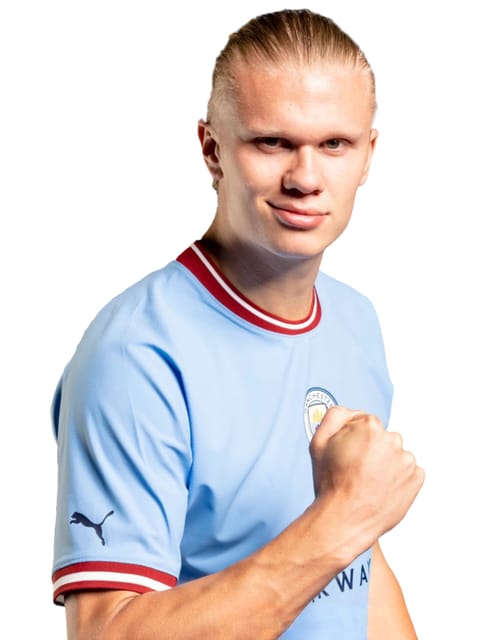 Portrait d'Erling Haaland aux cheveux blonds lissés en arrière, portant le maillot domicile bleu clair de Manchester City avec bordure de col rouge-blanc. Il a le poing levé et un léger sourire, sur un fond blanc uni.